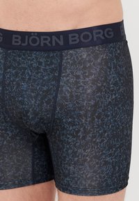 Σορτς μποξέρ σε σκούρο μπλε με λουλουδάτο σχέδιο. Μαλακό ύφασμα, ελαστική μέση με το λογότυπο "BJÖRN BORG" σε ναυτικό μπλε. Στενή εφαρμογή για άνεση.