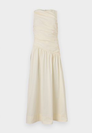 Αμάνικο κρεμ φόρεμα με ραβδωτό μπούστο και ασύμμετρη σούρα στη μέση, που ρέει σε μια μακριά, λείες φούστα.