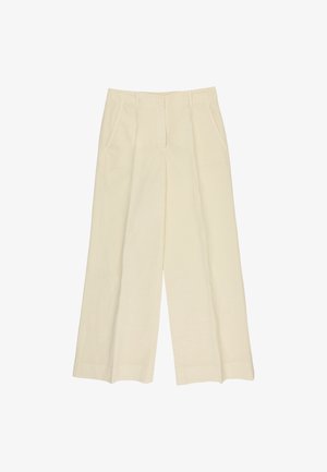 Pantalon beige à jambes larges avec poches avant, passants pour ceinture et fermeture éclair avant, présenté sur fond blanc.