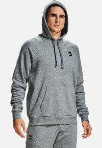 Grijze hoodie met een trekkoordkap, een voorzak en raglanmouwen. Bevat een klein zwart logo op de borst en ribgebreide manchetten.