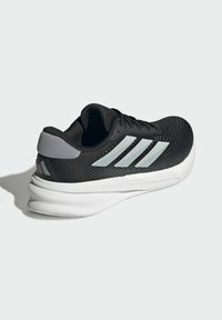 Black athletic shoe with a textured mesh upper, gray accents, white midsole, and three reflective stripes on the side.