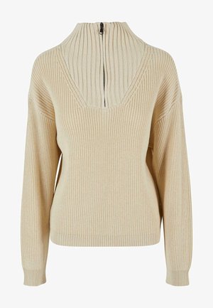 Beezist kootud kampsun ribatud kõrge krae, V-dekoltee ja selja tõmbluku sulgemisega. Omab laiu varrukaid ja tekstureeritud mustrit kogu ulatuses.