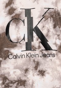Jasno kolorowa koszulka typu tie-dye z dużym czarnym logo "CK" oraz tekstem "Calvin Klein Jeans" wydrukowanym poniżej na czarno. Miękka tekstura materiału.
