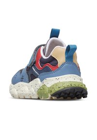 Mnohobarevná teniska s modrým koženým svrškem, červenými a béžovými akcenty, strukturovanou zelenou mezipodešví a černou gumovou podešví.