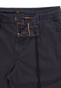 Marina casualbyxor med en slät yta, med dragkedjegylf, orange sömdetaljer och resåren i midjan för komfort.