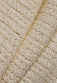 Crème-kleurige gebreide stof met een gestructureerd patroon van horizontale strepen en kleine gaten, met glanzende draden die er doorheen zijn geweven.