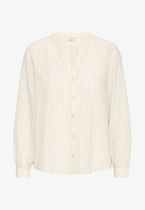 Kreminės spalvos mygtukų marškiniai su vertikaliu auksiniu ir smėlio spalvos dryžiu, pasižymintys V formos iškirpte ir ilgomis, šiek tiek pūstomis rankovėmis.