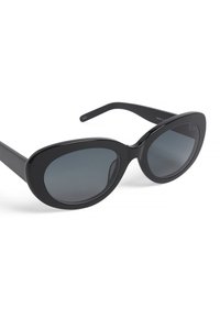 Sorte solbriller med en glat, blank ramme, der har overdimensionerede ovale linser i gradienttint. Designet inkluderer tykke stænger.