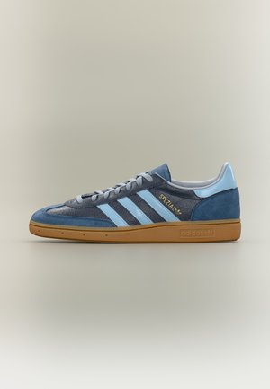 Sneaker Adidas Spezial blu con strisce azzurre, suola in gomma e scritta "SPEZIAL" in oro sul lato.