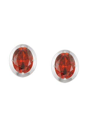 Paar silberne Ohrstecker mit oval geschliffenen, tiefroten Edelsteinen in Vier-Krappenfassungen auf weißem Hintergrund.