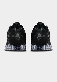 Μαύρα αθλητικά παπούτσια με υφή στο πάνω μέρος και επένδυση κάλτσας με σχέδια, με παχιά, διάφανη σόλα χωρισμένη σε τμήματα και ανάγλυφο λογότυπο.