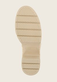 Schoenzool in beige rubber met hexagonale patronen, ribbelige secties en logo-engraving. Maat 40 aangegeven op de zool.