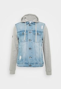 Chaqueta de mezclilla con capucha gris, de color azul claro, con detalles desgastados, cierres de botón y dos bolsillos en el pecho.