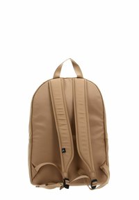 Sac à dos beige avec bretelles rembourrées et réglables ainsi qu'une poignée de transport en haut, présenté de dos sur un fond blanc.