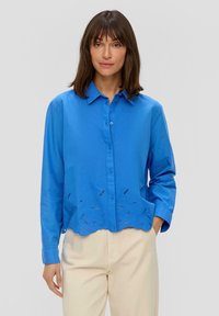 Camicia button-up blu in tessuto leggero, con orlo a scaglie e dettagli ricamati. Maniche lunghe con polsini a bottoni.