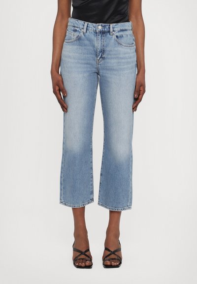 Jeans cropped bleu clair avec une coupe droite, présentant des détails décolorés et une fermeture à bouton à la taille.