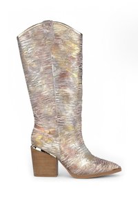 Botas de cowboy metálicas en plata y oro con punta afilada, parte superior de cuero texturizado y un tacón de madera apilado. Patrón de costura detallado.