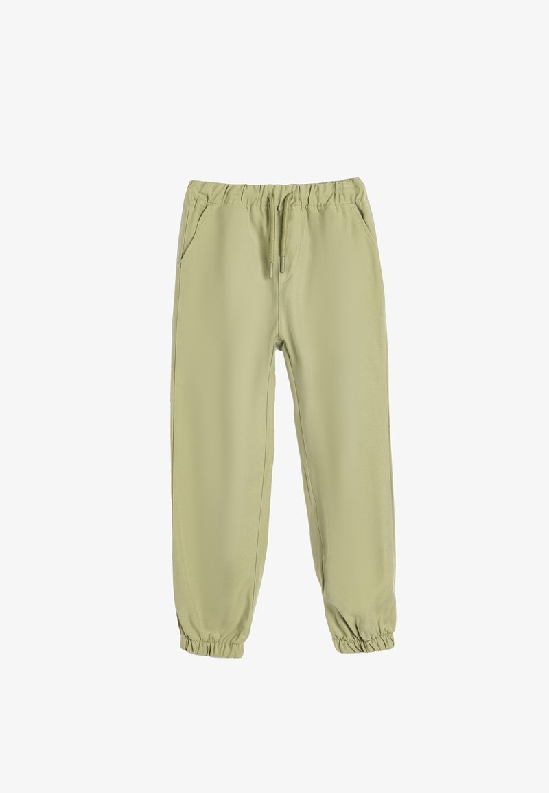 Lys grønne bukser med elastik i taljen, side lommer, elastiske manchetter og en glat tekstur. Designet for komfort og nemt at have på.