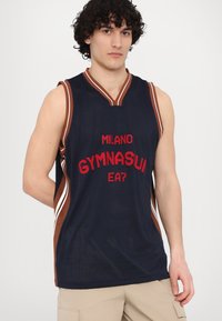 Modrý síťovaný basketbalový dres s červeným nápisem "MILANO GYMNASIUM EA7", hnědým lemem a designem ve tvaru V; obsahuje boční pruhy.