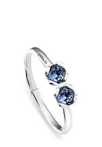 Anillo de plata con dos piedras de cristal azul en engastes con forma de flor, con una banda suave y el nombre de la marca grabado.
