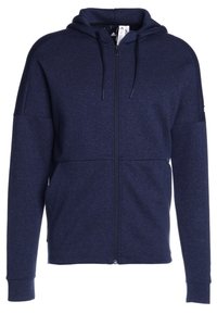Felpa con zip di colore blu navy realizzata in un morbido tessuto testurizzato. Presenta un cappuccio con cordino, maniche lunghe e un design aderente. Linee pulite e senza motivi.