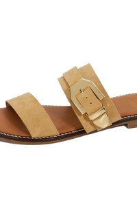 Sandale à glissière en daim beige avec une large bride, accessoires en boucle en or et une semelle en cuir brun. Présente un contour cousu le long du bord.