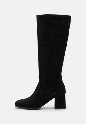 Bottes noires montantes en daim avec un talon carré, présentant une texture lisse et un design épuré, sans quincaillerie ou accents visibles.