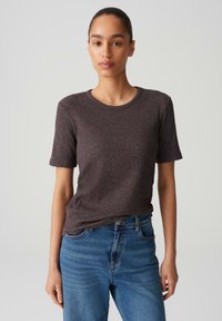 Dark brown ribbed t-shirt with short sleeves and a round neckline, paired with light blue straight-leg jeans. Smooth texture, casual fit.