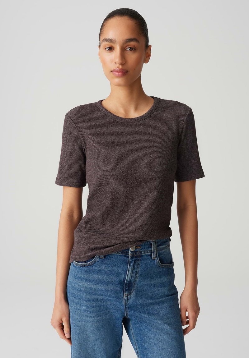 Dark brown ribbed t-shirt with short sleeves and a round neckline, paired with light blue straight-leg jeans. Smooth texture, casual fit.