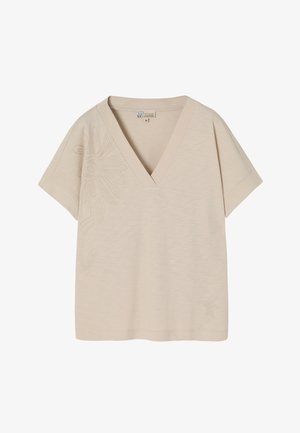 Beige V-Ausschnitt T-Shirt mit kurzen Ärmeln. Mit floralem Stickmuster auf der linken Seite und einem weichen, strukturierten Stoff. Lockere Passform.