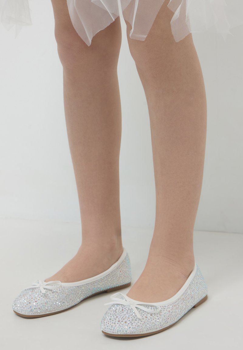 Balletschuhe mit glitzerndem, schimmerndem Finish, weißem Besatz und kleinen Schleifendetails. Flache Sohle und runde Zehenform.