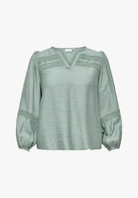 Blusa verde chiaro con scollatura a V, tessuto texture e maniche lunghe a sbuffo. Presenta dettagli intrecciati lungo il petto e le maniche.