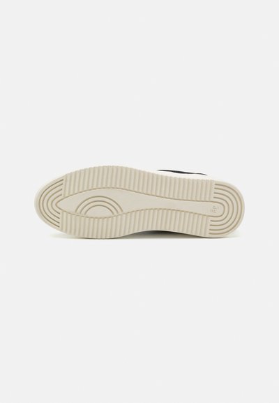 Black sneaker sole with textured, patterned design. Firm rubber construction with ridges and curved accents, featuring a light-colored outsole.