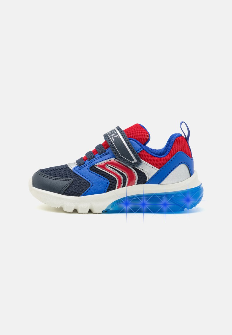 Chaussure de sport bleue et rouge avec un dessus en maille texturée, une sangle Velcro et une semelle translucide équipée d'accents lumineux.