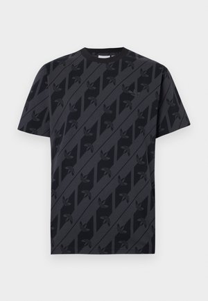 T-shirt nera a maniche corte con strisce diagonali grigio scuro e motivo ripetuto del logo trifoglio nero su tutto il tessuto.