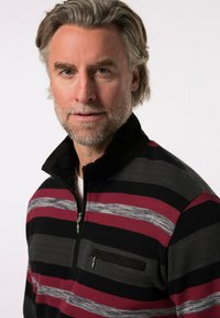 Černý, červený a šedý pruhovaný svetr na zip s límečkem, který má náprsní kapsu a texturovanou látku.