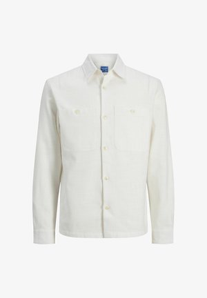 Chemise à manches longues en lin écru, dotée d'un col à boutons, de deux poches poitrine et d'une fermeture avant à boutons. Texture lisse.