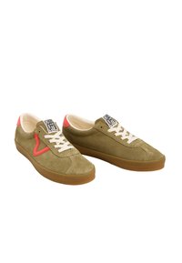Sneakers in suede verde con lacci color avorio, suola in gomma naturale e dettagli in rosa vicino al tallone. Presentano il logo sulla linguetta e un design curvo ai lati.