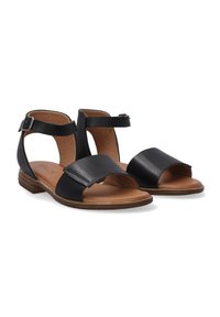 Černé kožené sandály s otevřenou špičkou, sankou na kotníku a plochou hnědou dřevěnou podrážkou. Mají široký přední pás a akcent z přezky.