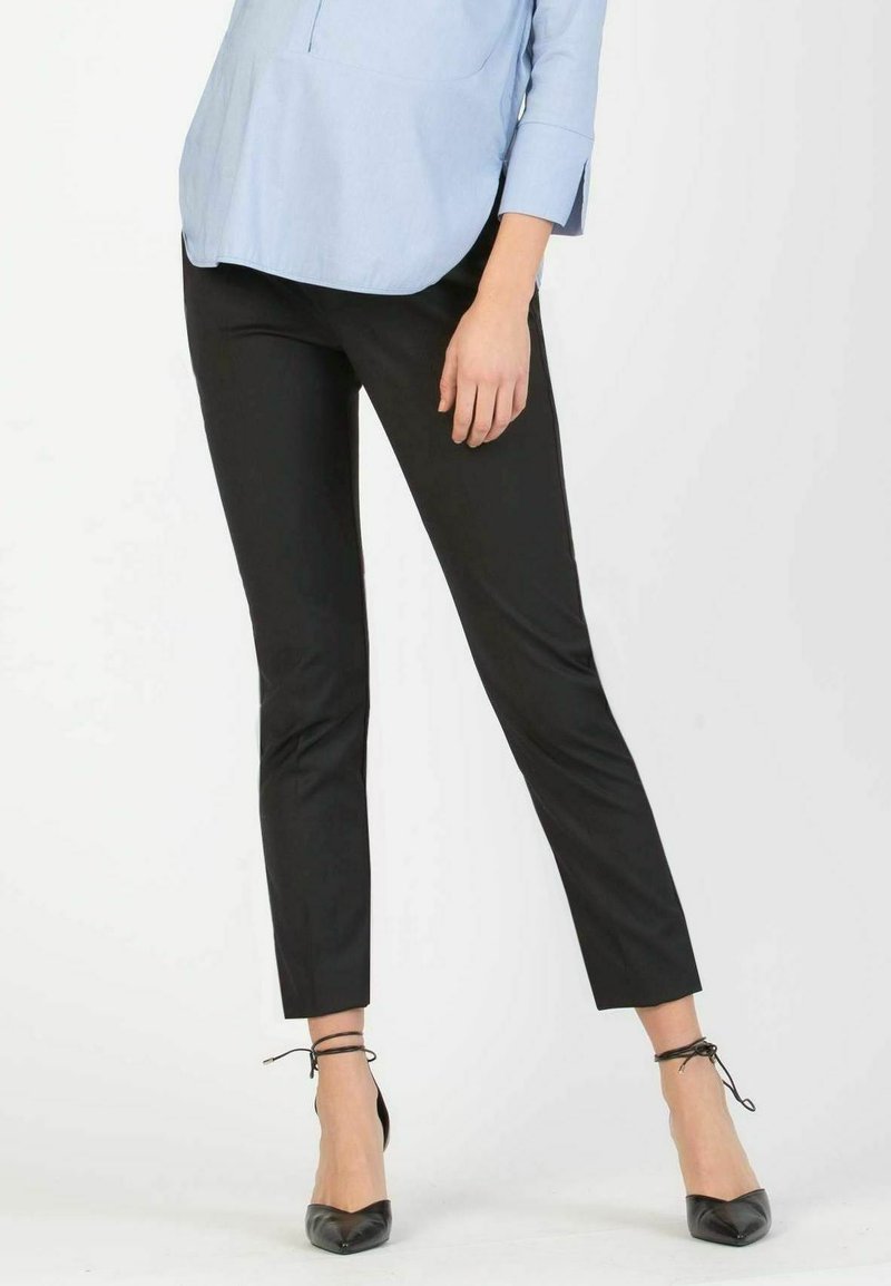Black tailored trousers with a slim fit, lightweight fabric, and a cropped length. Paired with black flats and a light blue shirt.