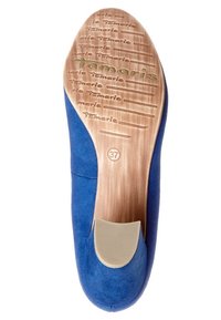 Blå mockaskor med platt design, som har en beige gummisula och präglad logotyp. Storlek 37 märkt på undersidan.