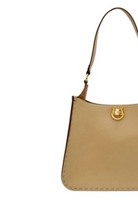 Beige läderhandväska med ett enda handtag och en gyllene hästskoformad lås framifrån mot vit bakgrund.