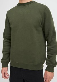 Olijfgroene sweatshirt met een ronde hals, ribgebreide manchetten en zoom. Zachte textuur, casual ontwerp en minimale stikdetails.