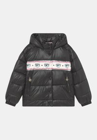 Černá nadýchaná bunda s kapucí, s růžovo-bílým pruhovaným panelem zdobeným motivy očí. Obsahuje boční kapsy na zip.