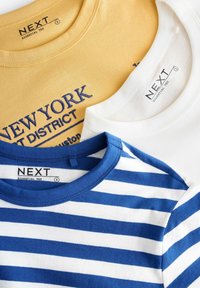 Drei übereinander gestapelte T-Shirts: eines in Senfgelb mit blauer Schrift, eines weiß und eines blau-weiß gestreift. Alle haben einen Rundhalsausschnitt und sichtbare Markentags.