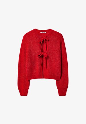Punane kudumine cardigan lühikese lõikega, ümmarguse kaelusega, pikkade varrukatega ja kahe esiseotud nurgaga. Pehme tekstuur koos peene läikega.