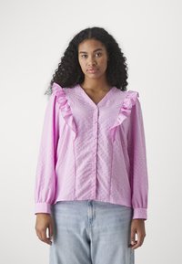 Blusa rosa con dettagli arricciati sulle spalle, chiusura a bottoni e maniche lunghe. Realizzata in tessuto testurizzato con una vestibilità comoda.