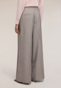 Pantaloni a gamba larga grigi con righe verticali, dotati di vita alta, tasche posteriori e un tessuto liscio e texturizzato.