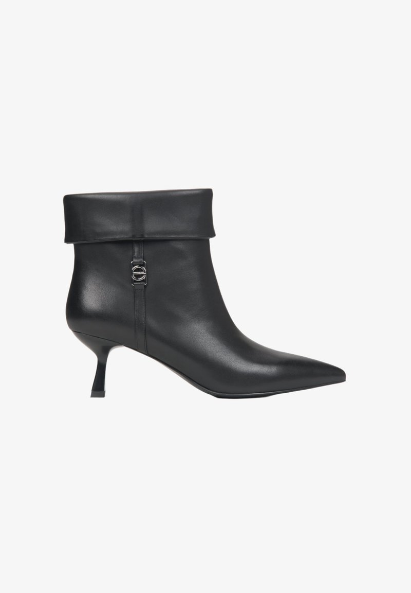 Botte de cheville en cuir noir avec un revers roulé, une pointe pointue et un petit talon. Présente un accent argenté sur le côté. Texture lisse.