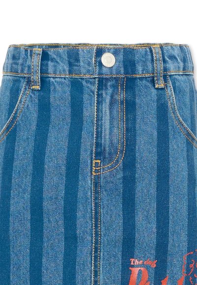 Jupe en denim bleu taille haute avec rayures verticales, fermeture par boutons, passants pour ceinture, poches avant et petit motif de chien rouge sur le côté inférieur droit.